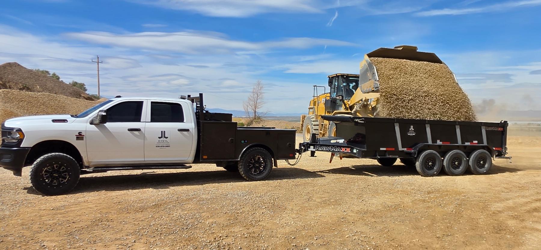 A J&J truck and dump trailer being loaded with base material at the pit